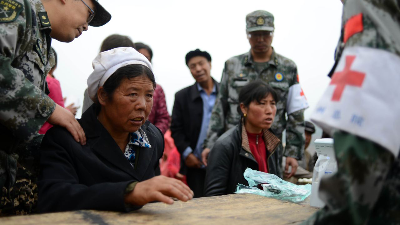 Villagers receive treatment from military medics in Yongxing, China, on July 23. Rescuers are searching for survivors in the aftermath of the quake. 