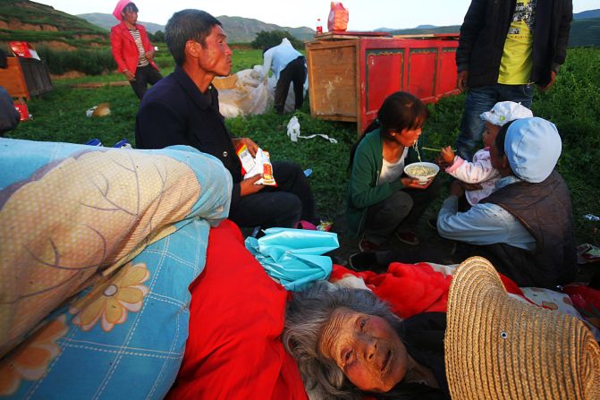 JULY 23 - MAJIAGOU, CHINA: Survivors of a deadly earthquake in northwest China's Gansu province eat instant noodles in a clearing after their homes were damaged. At least <a href="http://cnn.com/2013/07/21/world/asia/china-quake/index.html?hpt=ias_c2">89 people died and 600 others were injured</a> in the quake, according to state media.