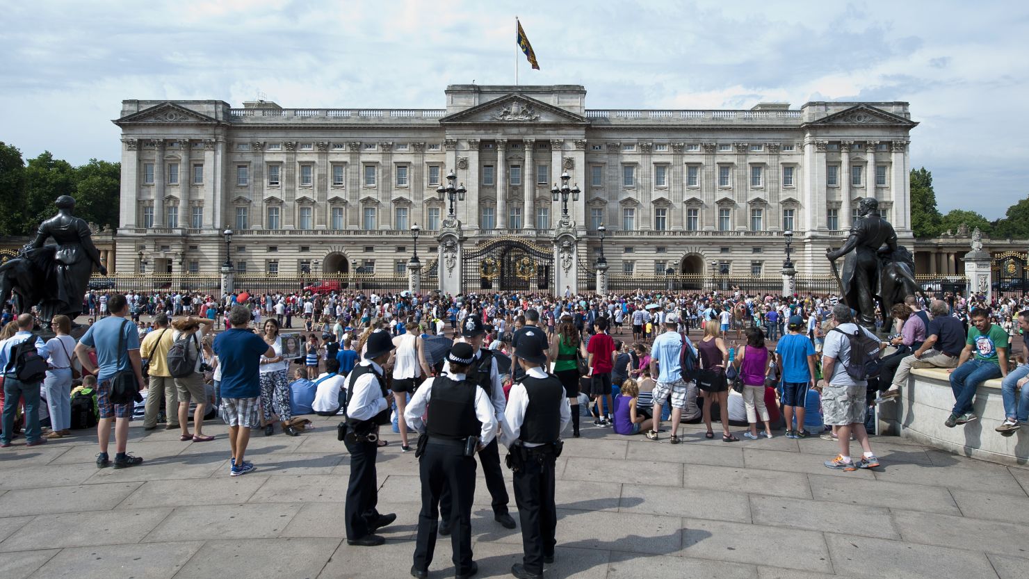 Members of the public and tourists gather outside Buckingham Palace in London in July.