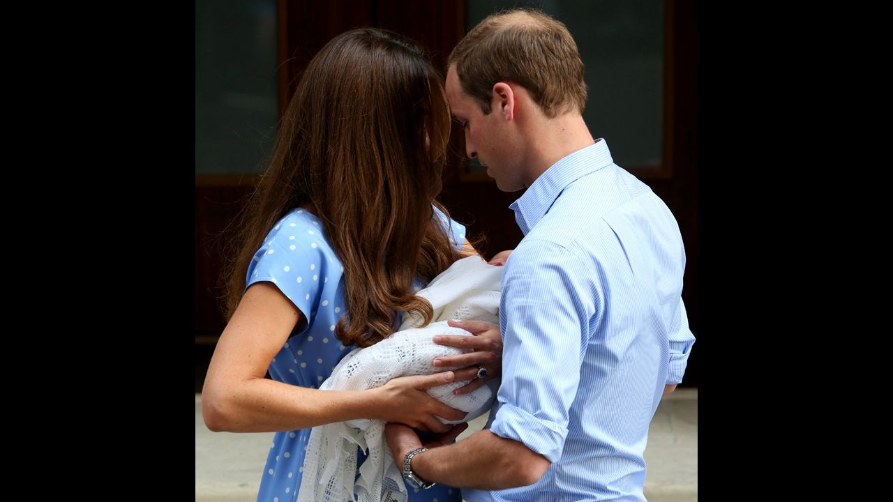 Catherine hands the baby off to William. 
