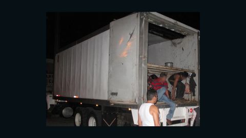Migrants exit from the back of the truck.