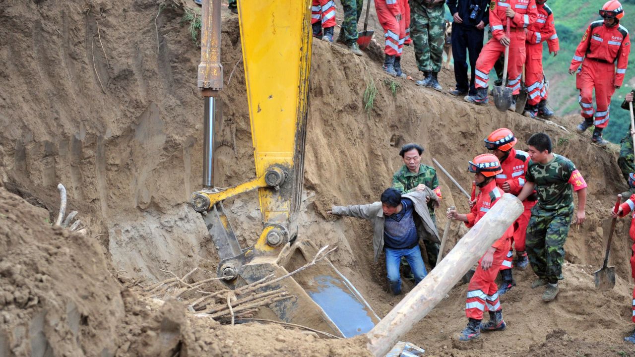A man reacts after seeing his wife's shoes as rescuers search for earthquake survivors in Yongguang township, in northwest China's Gansu province, on Tuesday, July 23.