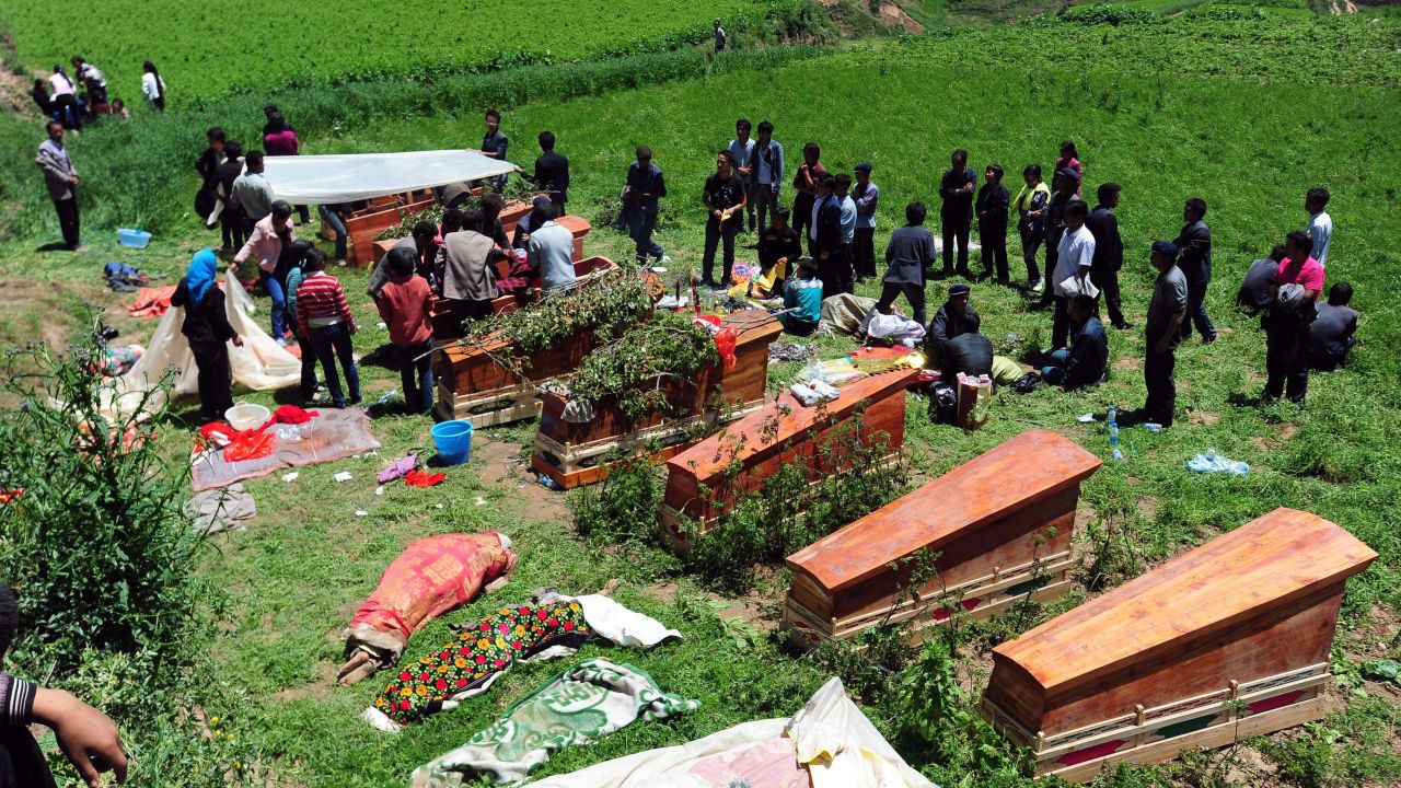 People gather to bury the dead in Yongguang, China, on July 23.