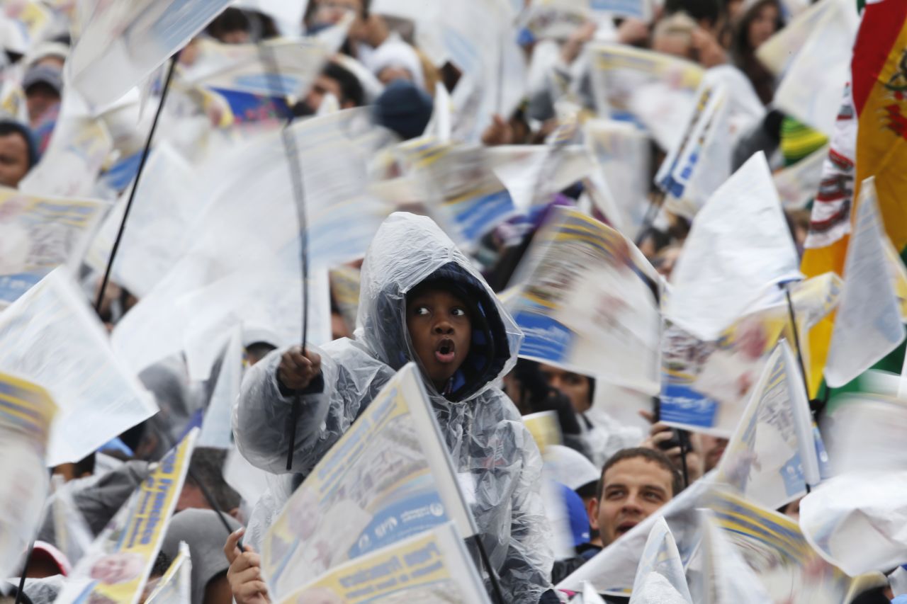 A boy waves a flag along with the other faithful to see the pope in Aparecida on July 24.