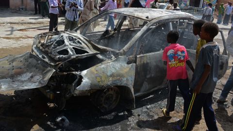 Somali children look at a burnt car after a bomb blast in Hamarweyne Market in Mogadishu on July 24, 2013.