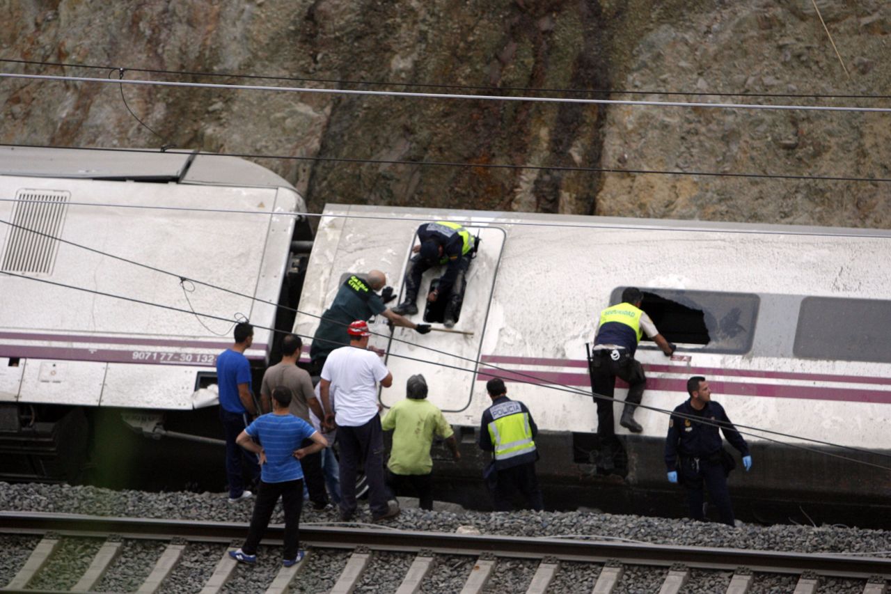 Rescuers work to pull victims from the derailed cars. 