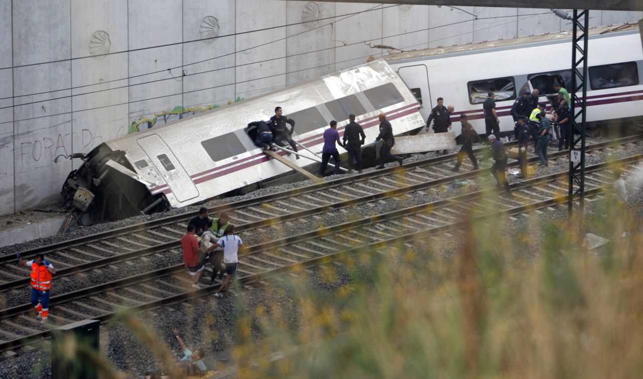 Rescuers work to clear a derailed car. 