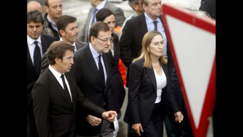 Spanish Prime Minister Mariano Rajoy, center, visits the crash site July 25 with Public Works Minister Ana Pastor, right, and Alberto Nunez Feijoo, head of the regional government in Galicia. The latter declared seven days of mourning for victims of the crash.<br />