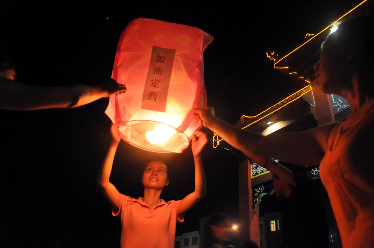 People pray for the earthquake victims in Laibin, China, on July 24.