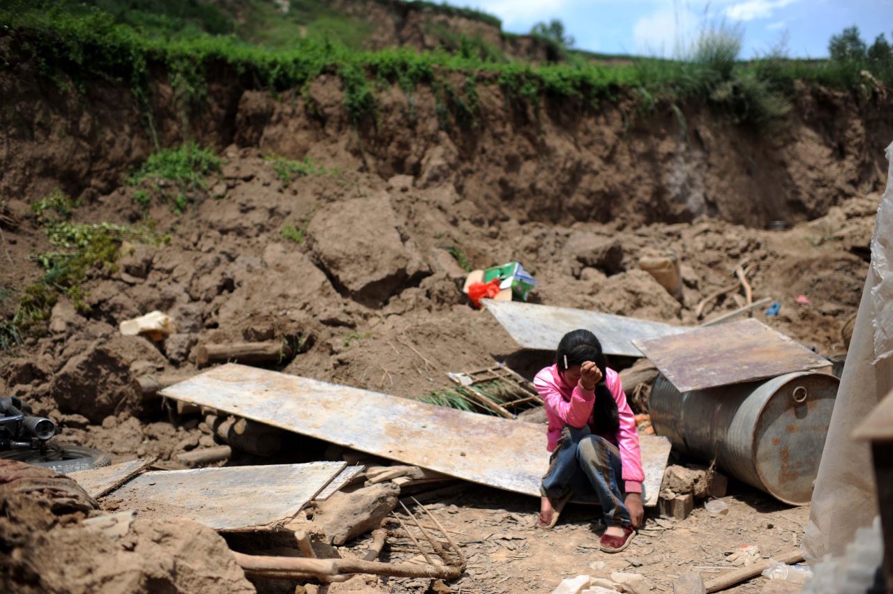 Song Xiaomei cries on Wednesday, July 24, after her home was destroyed by an earthquake in northwest China's Gansu province. The strong, shallow earthquake and powerful aftershocks jolted the region Monday morning.  The death toll is at 89, as of Friday, July 26.