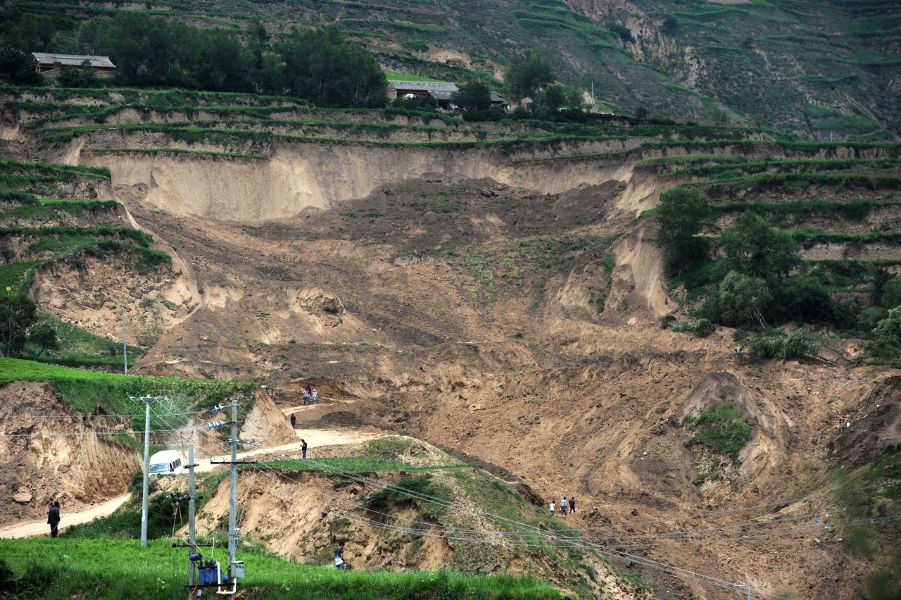 People look at damage on July 24 from a landslide triggered by Monday's earthquake.
