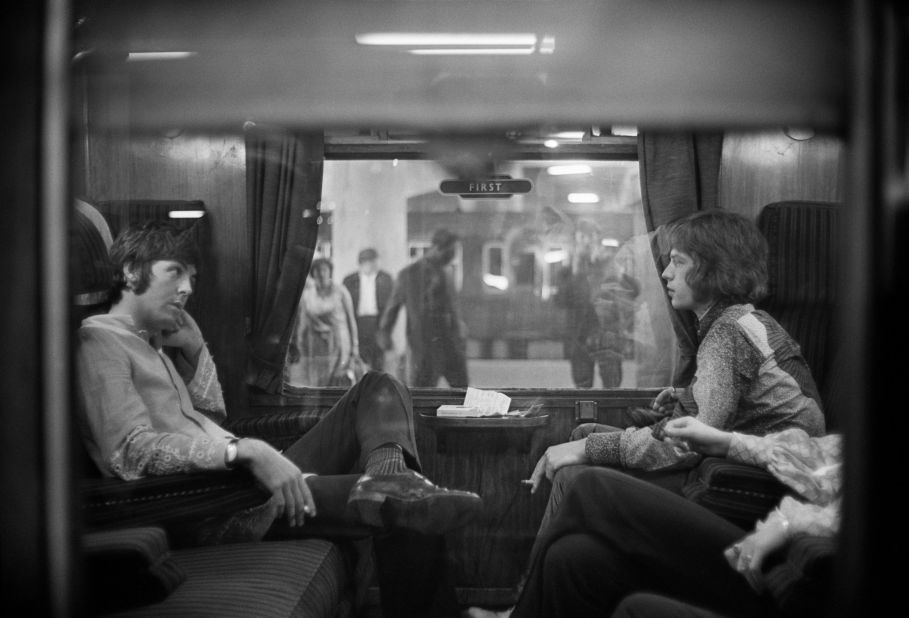 Paul McCartney of the Beatles, left, sits across from Jagger on a train at London's Euston Station in 1967.