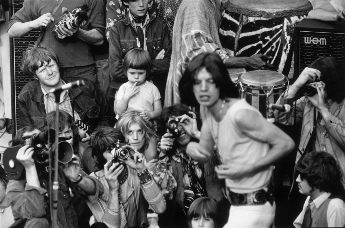Jagger performs with the Rolling Stones in central London's Hyde Park in 1969. His then-girlfriend Marianne Faithfull watches from behind the photographers.