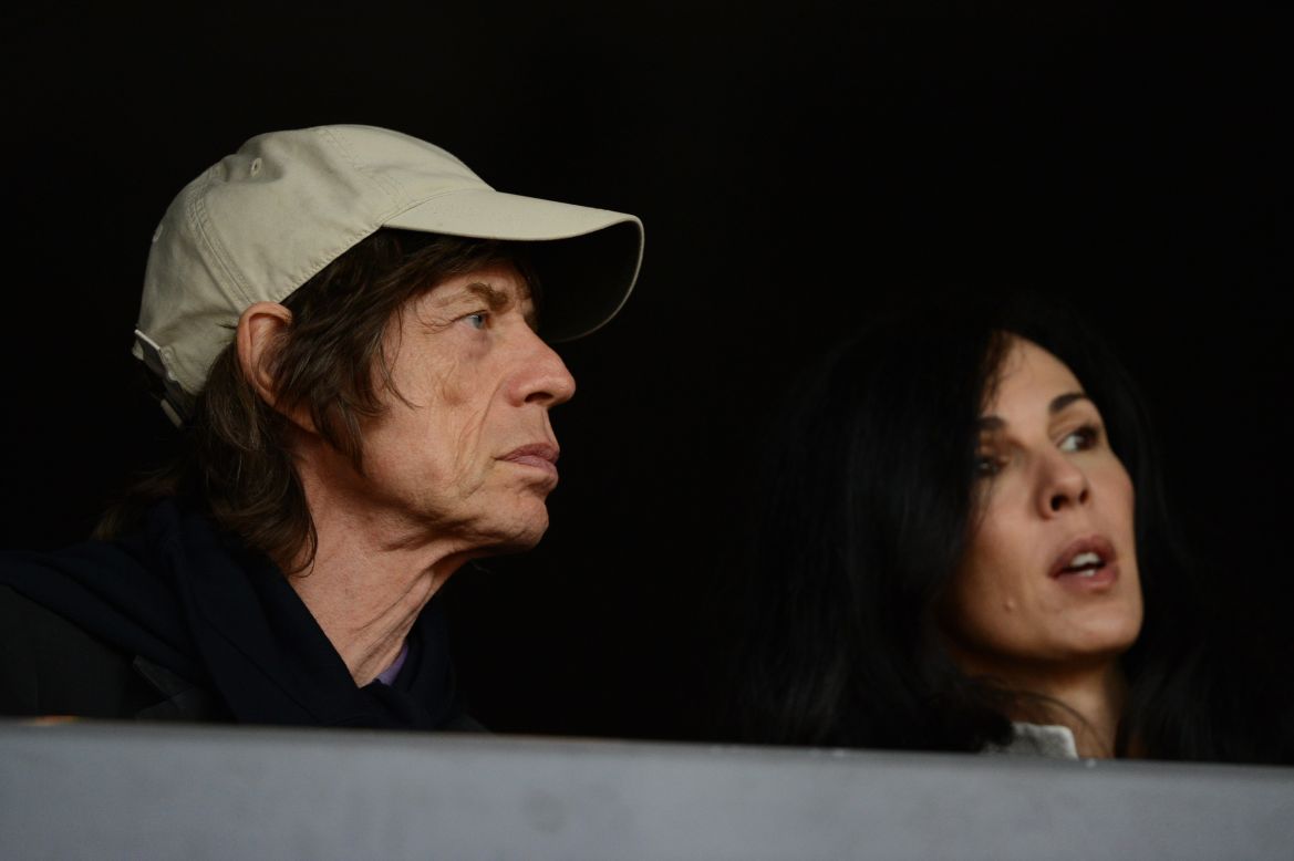Jagger watches the 2012 Olympic Games in London with his girlfriend, American fashion designer L'Wren Scott. Scott died in 2014.