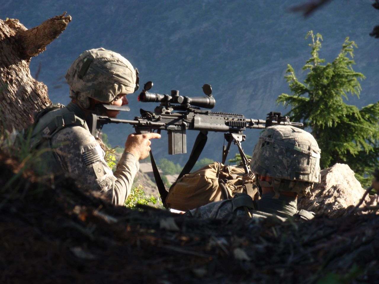 Carter with Spc. John Adams on their first patrol in Afghanistan. They are observing the Village of Kamdesh from a ridgeline between Observation Post Fritsche and the village. 