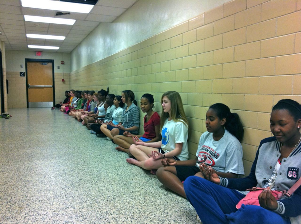 Students at Druid Hills Middle School in Dekalb Country, Georgia, inhale and exhale deeply to control their breathing as they sit in lotus pose. 