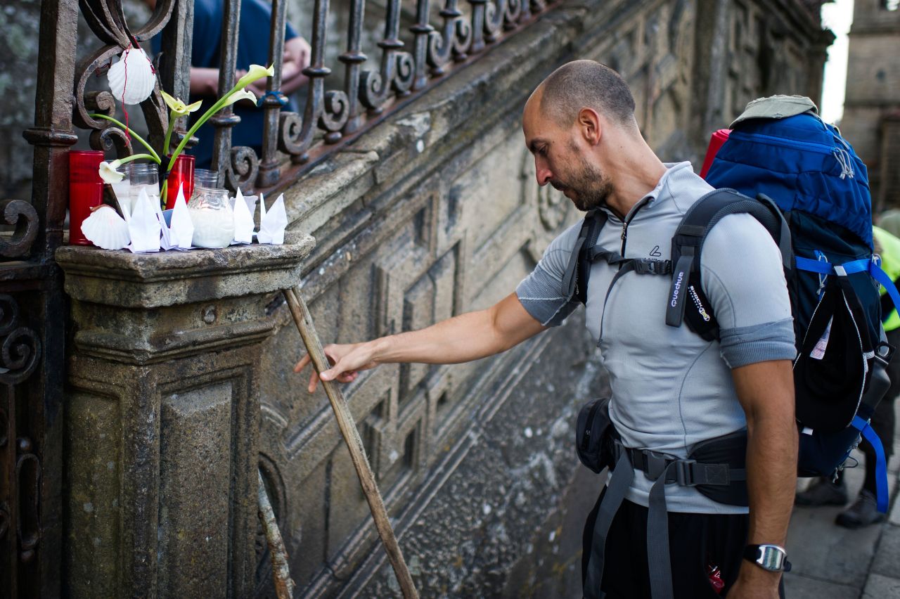 A man leaves his cane next to candles in memory of the train crash victims on Friday, July 26, in Santiago de Compostela.