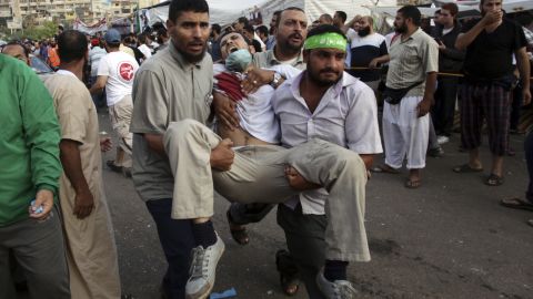 Supporters of Morsy carry an injured man to a field hospital amid clashes with security forces in Cairo on July 27.