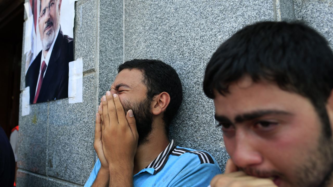 Two men mourn Morsy supporters who were killed in overnight clashes with security forces, in Cairo, on July 27.