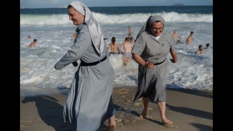Two Polish nuns laugh as they enjoy the surf along with the massive crowd gathering on Copacabana Beach on July 27. 