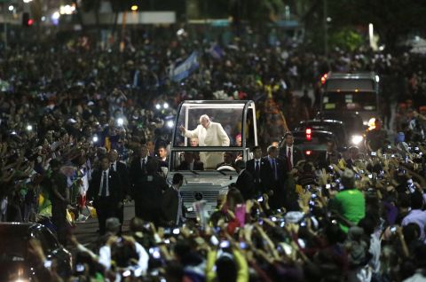 Pope Francis waves from the "Popemobile" as it threads its way through the crowd waiting for the vigil to begin on July 27. 