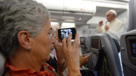 A journalist takes a picture of Pope Francis during the press conference on the flight back to Italy. The pope said the role of women in the church should be deeper, but he brushed aside the possibility of women being ordained as priests. "The church says no. That door is closed."