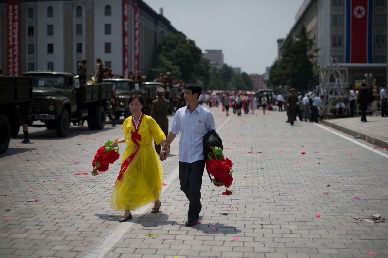 A couple walks through Kim Il Sung Square after a parade in Pyongyang on July 27.  
