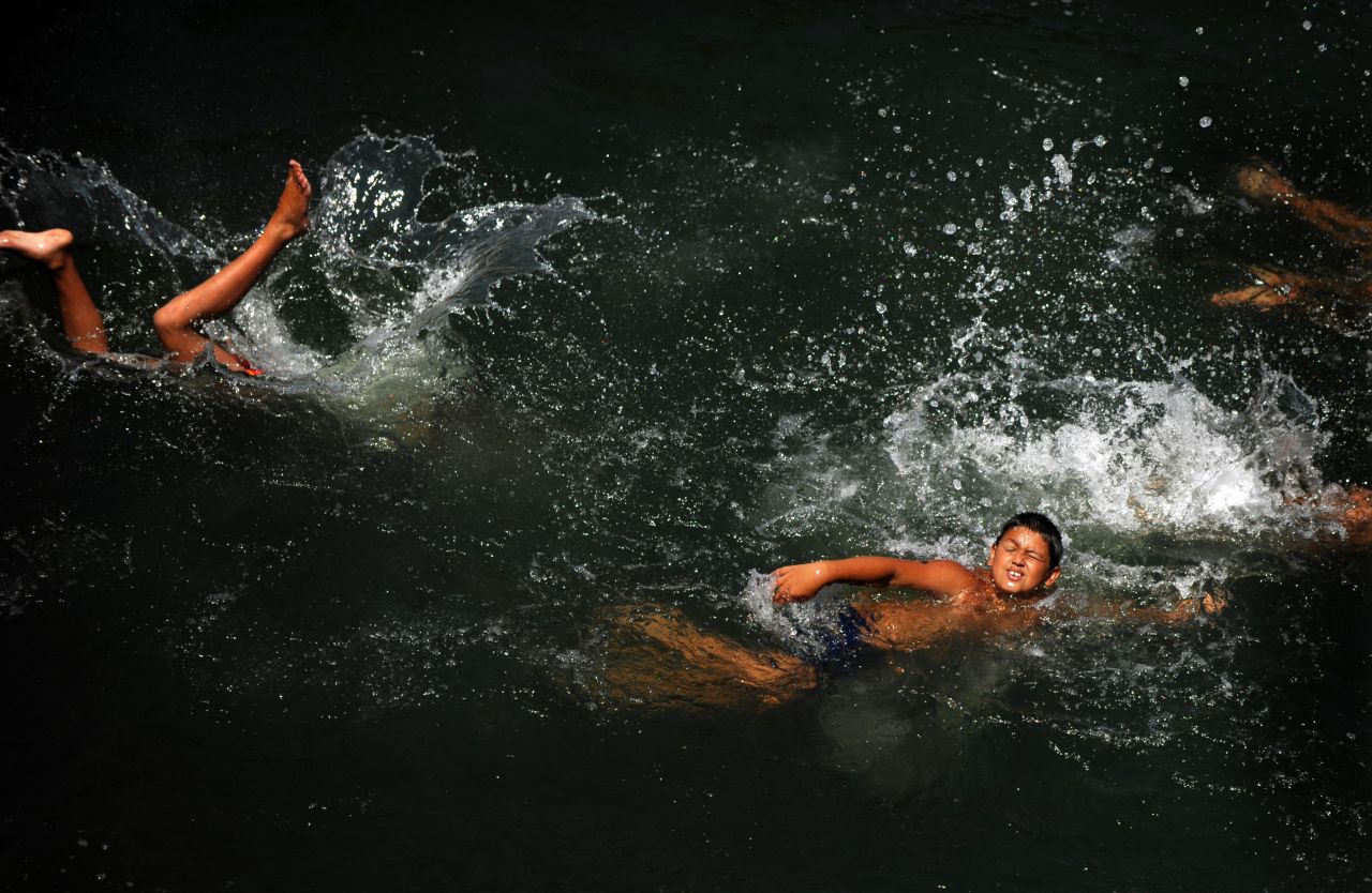 Children take the plunge to cool off in Sofia, Bulgaria, on Monday, July 29.