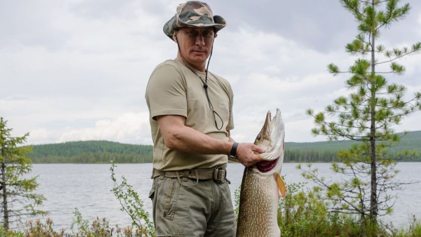 Russian President Vladimir Putin holds a huge pike fish, after he caught it in the Tyva region on July 20, 2013 during his vacation.