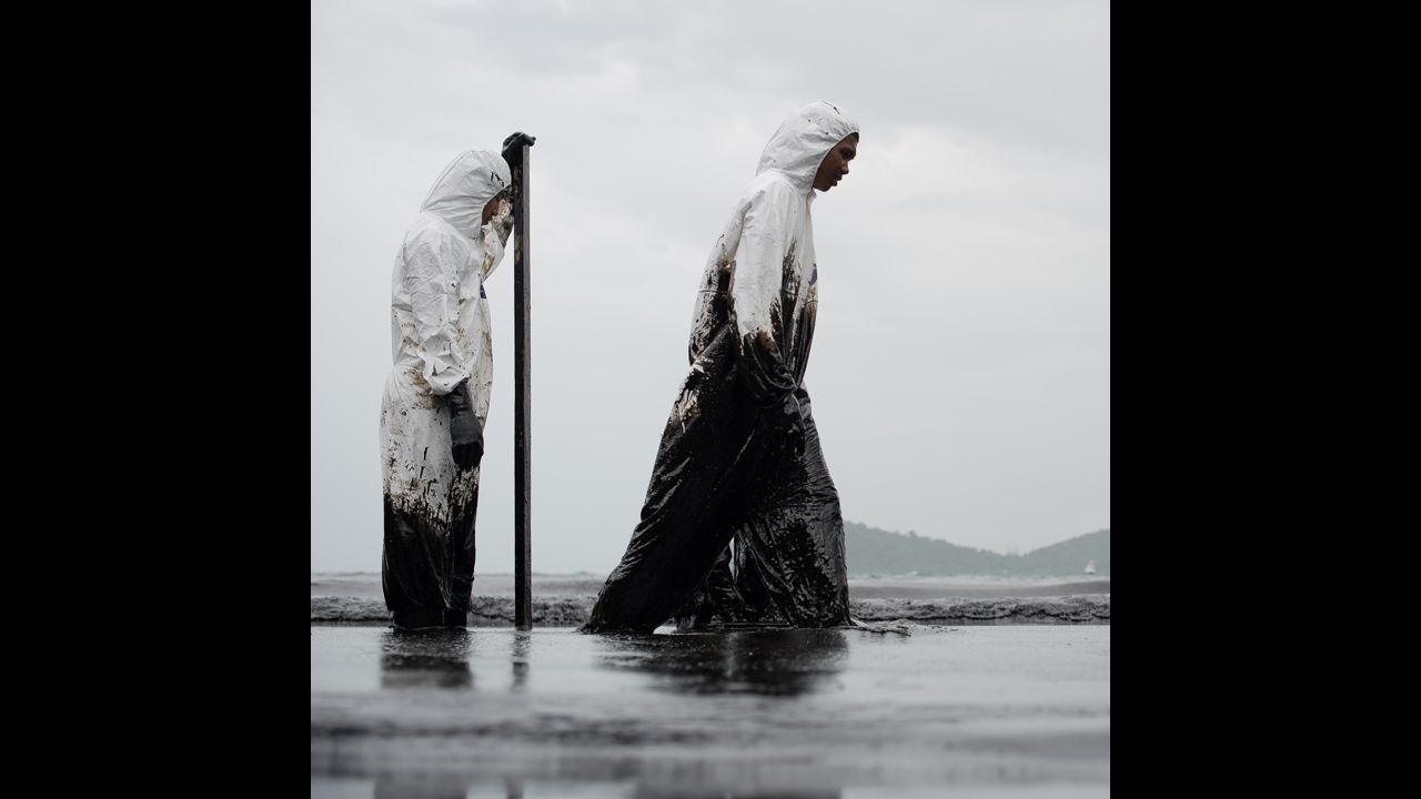 Thai navy workers move through the sludge on July 30.