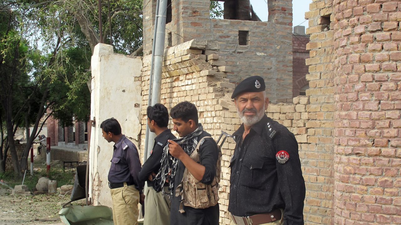 Policemen stand outside the Central Prison after an overnight Pakistan Taliban militant attack in Khyber Pakhtunkhwa on July 30.