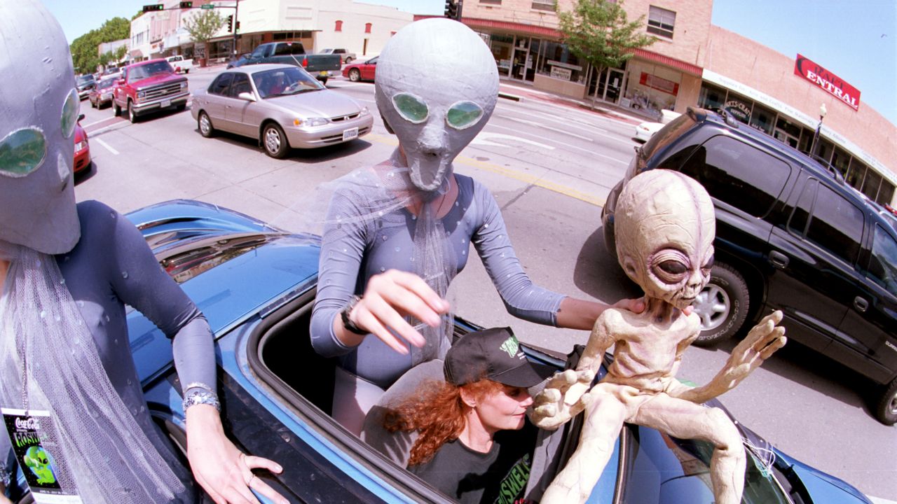 Groups dressed as aliens ride through downtown Roswell, New Mexico, in July 2000 as they participate in the annual UFO Encounter.