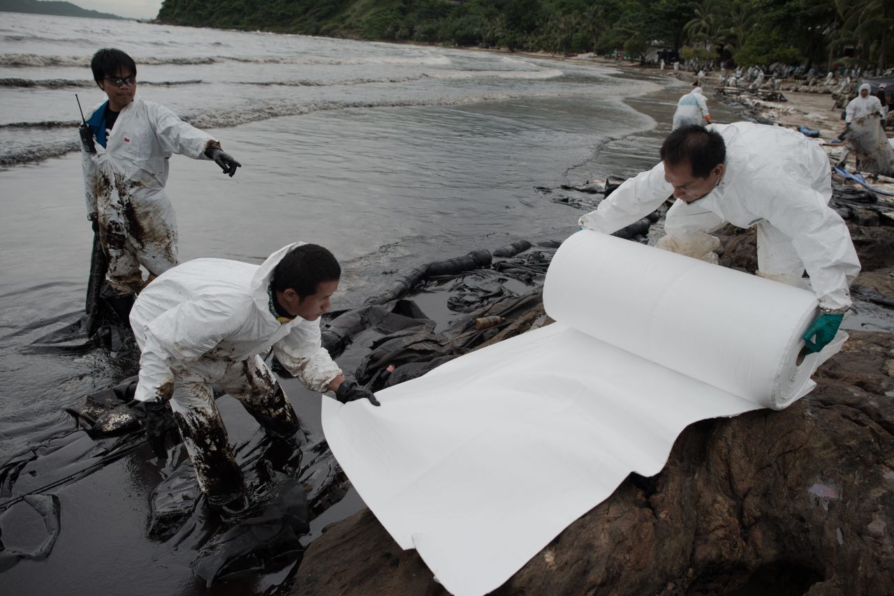 Thai navy personnel work to clean up the oil spill on Ao Phrao beach on July 30.