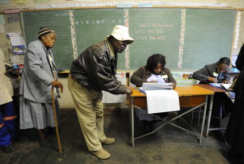 Zimbabweans arrive to vote at a polling booth in a school in Harare on July 31.
