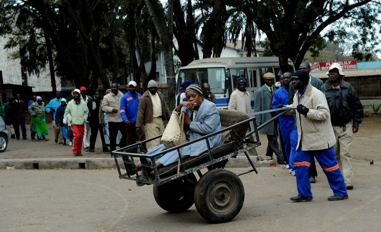 Chizema Najika, an eighty year old voter, arrives to vote at a polling booth in a school in Harare on July 31.