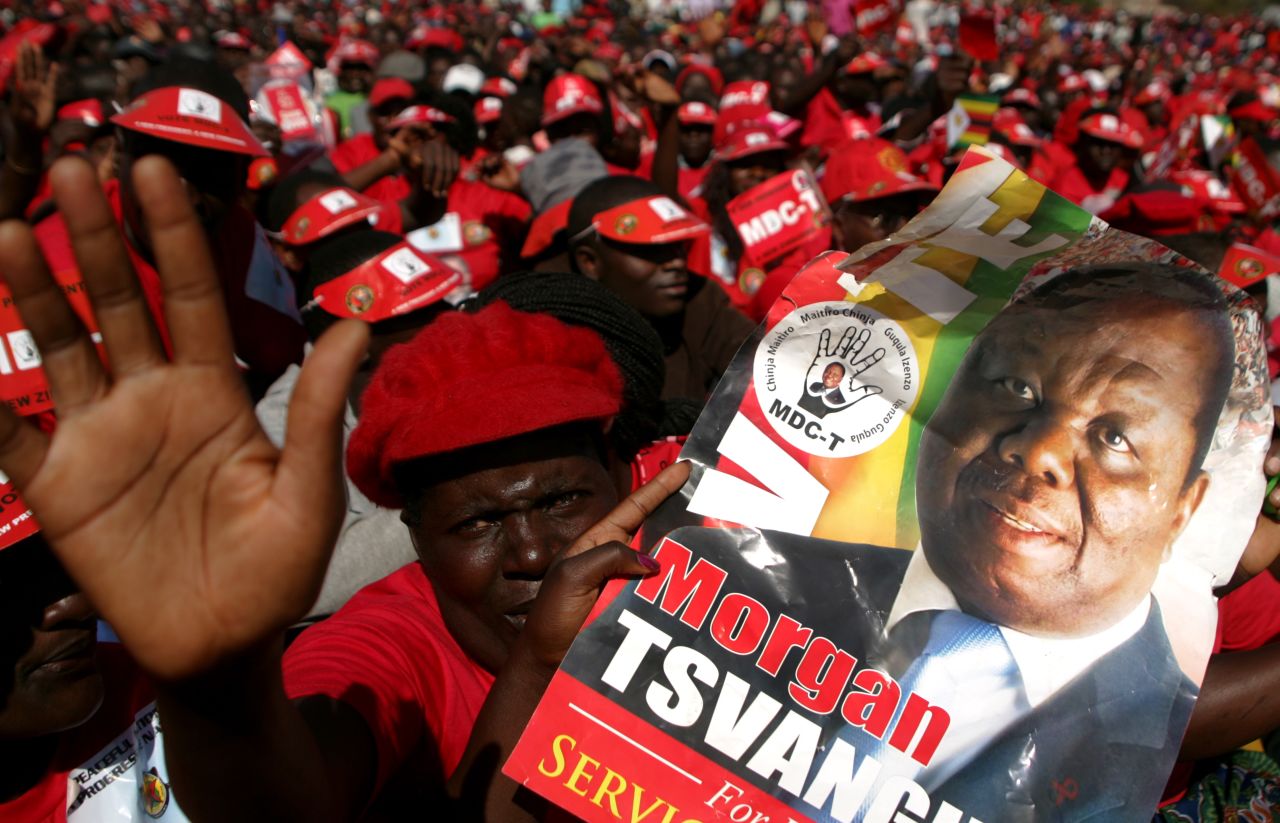 Supporters of the Movement for Democratic Change presidential candidate Morgan Tsvangirai hold his portrait as they attend the final campaign rally 'Cross Over' on July 29 in Harare. 
