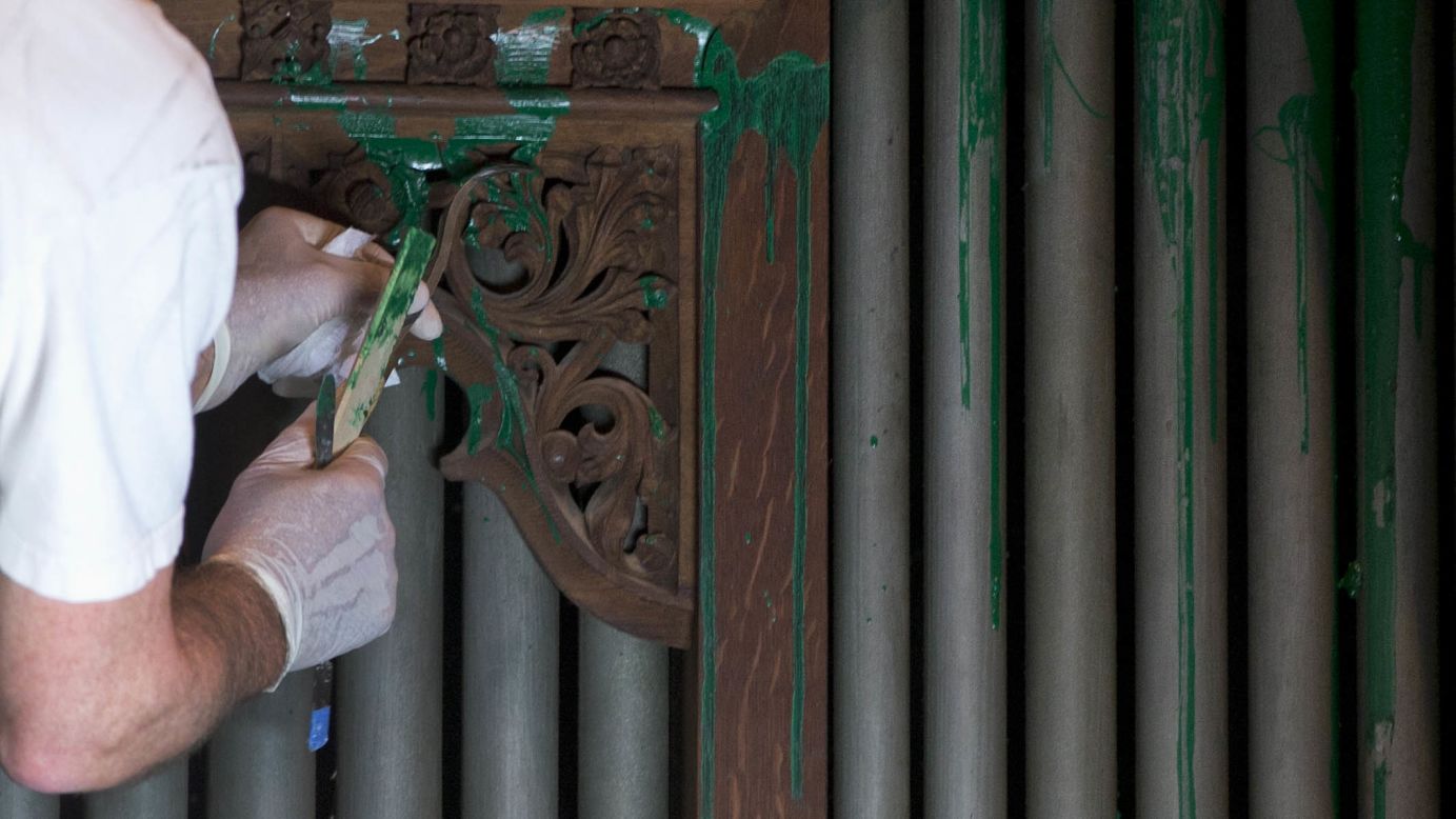 William Adair of Gold Leaf Studios removes paint from the organ in the Bethlehem Chapel on July 30.