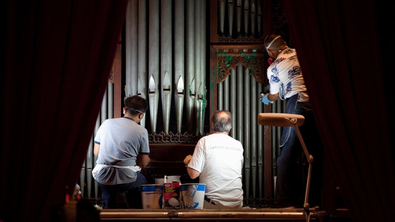 Gold Leaf Studios members remove paint from the organ in Bethlehem Chapel on July 30.