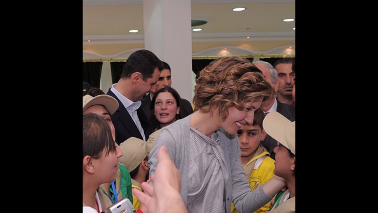 Asma al-Assad shows affection to the children surrounding her. 
