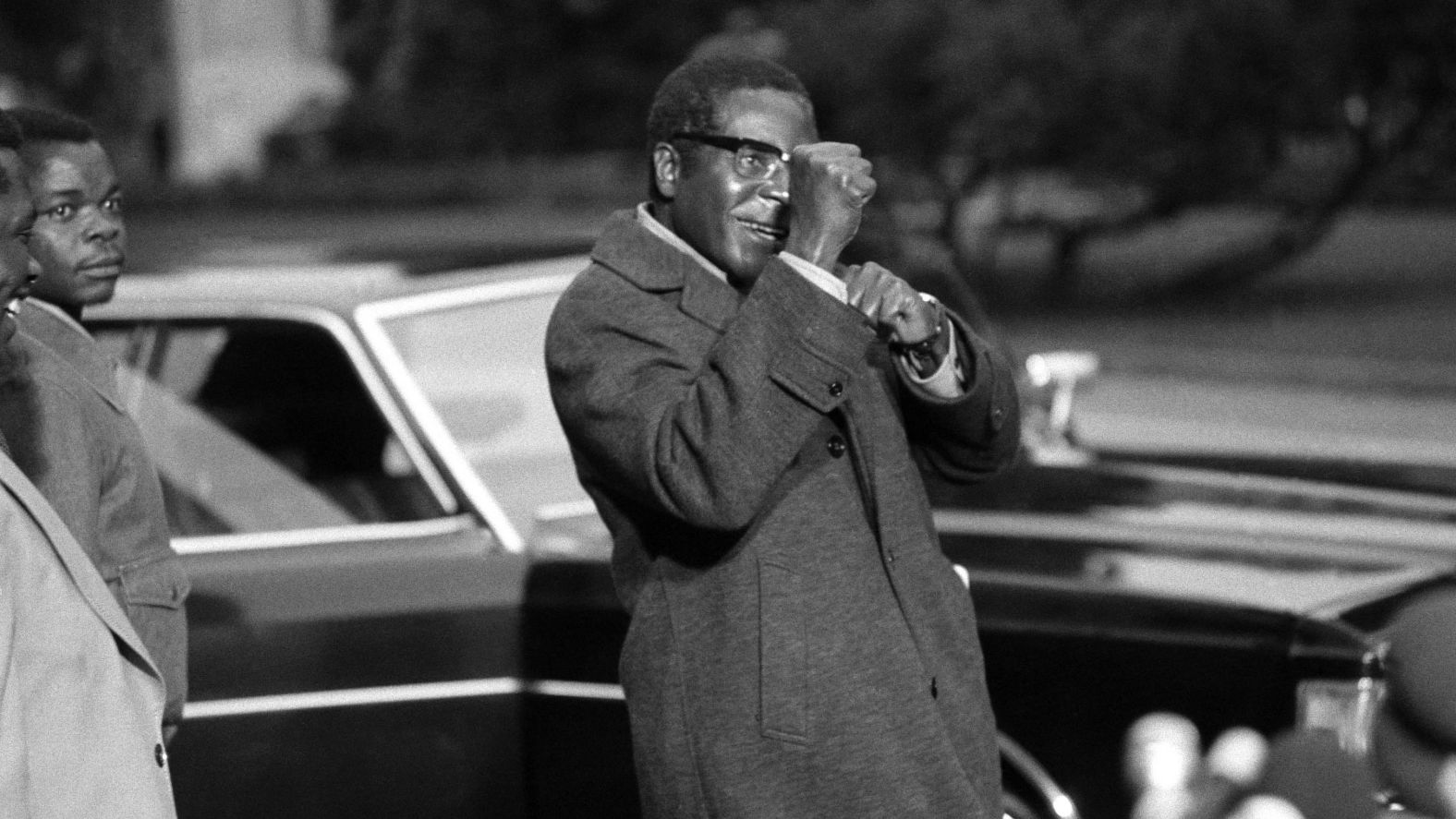 Mugabe gestures towards the media in Geneva, Switzerland, at a 1974 conference convened to address the civil war in Rhodesia. After being imprisoned for 10 years in Rhodesia, Mugabe attended the peace talks as a leader of the guerrilla movement ZANU-PF (Zimbabwe African National Union-Patriotic Front). Rhodesia was the state that eventually became Zimbabwe.
