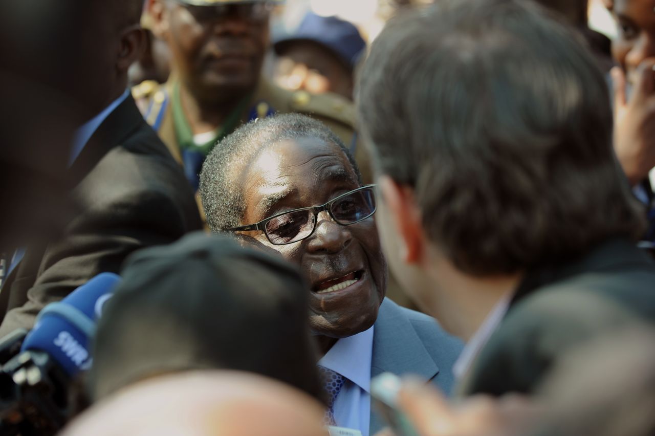 Zimbabwe President Robert Mugabe answers journalists questions after voting at a polling station at a school in Harare.