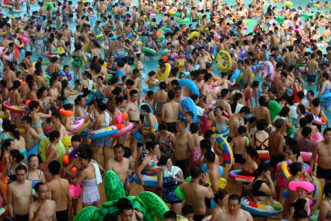 Mass crowds of people attempt to cool off at a water park in Suining, Sichuan province on Saturday, July 27, amid a record heat wave hitting 19 provinces and regions in China.  