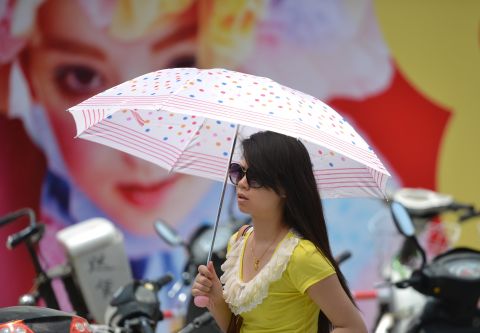 A woman uses an umbrella as sun protection  as a heatwave hits Shanghai on Thursday, July 4.