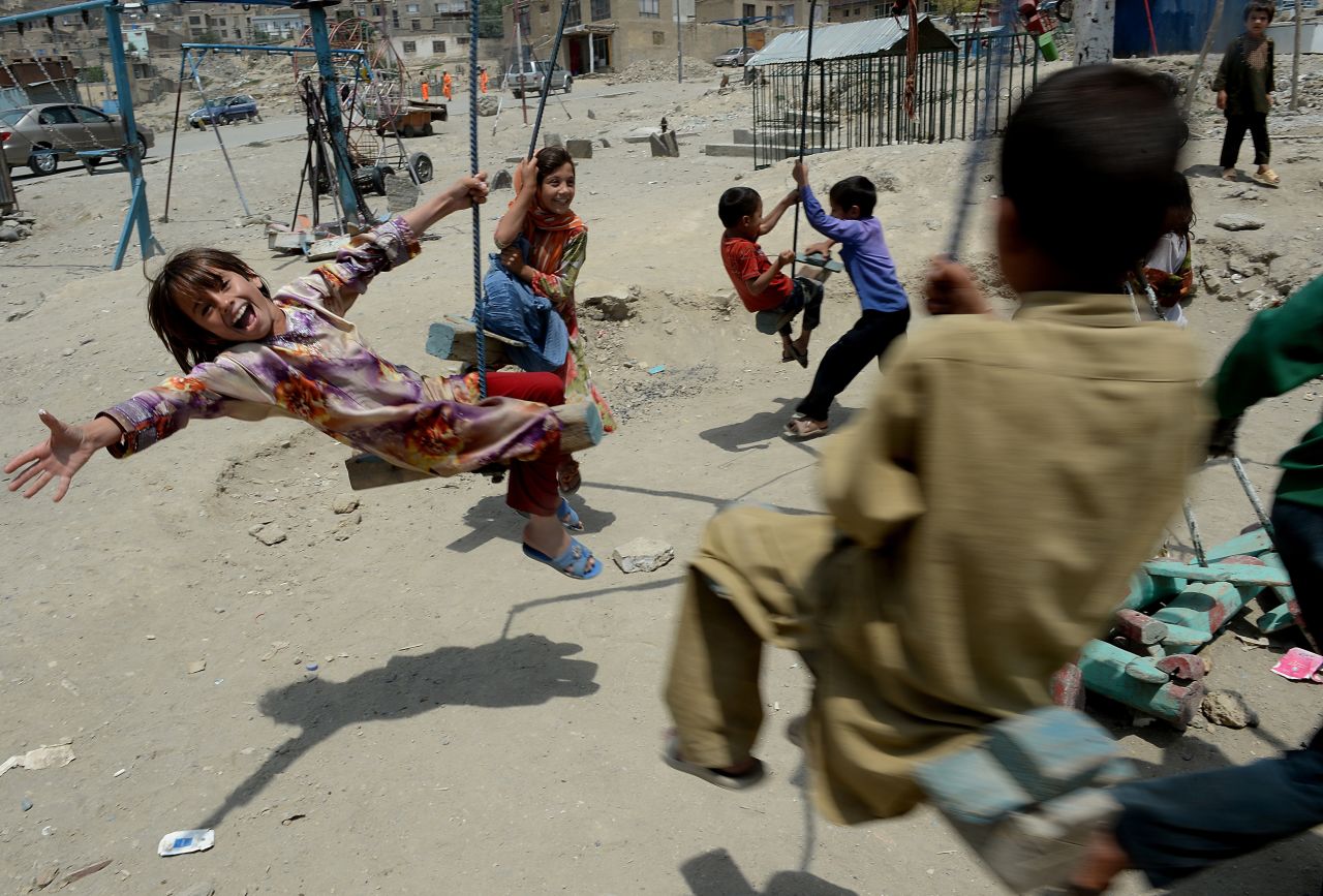 August 1 - KABUL, AFGHANISTAN: Children play on a swing near a cemetery in Kabul. The number of civilians killed in Afghanistan increased by nearly a quarter in the first six months of this year, the <a href="http://cnn.com/2013/07/31/world/asia/afghanistan-civilian-casualties/index.html?hpt=ias_c2">United Nations said in a report</a>. Most of the 1,319 civilians killed so far this year were victims of the Taliban.