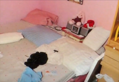 Stuffed animals lie on a bed in the house.