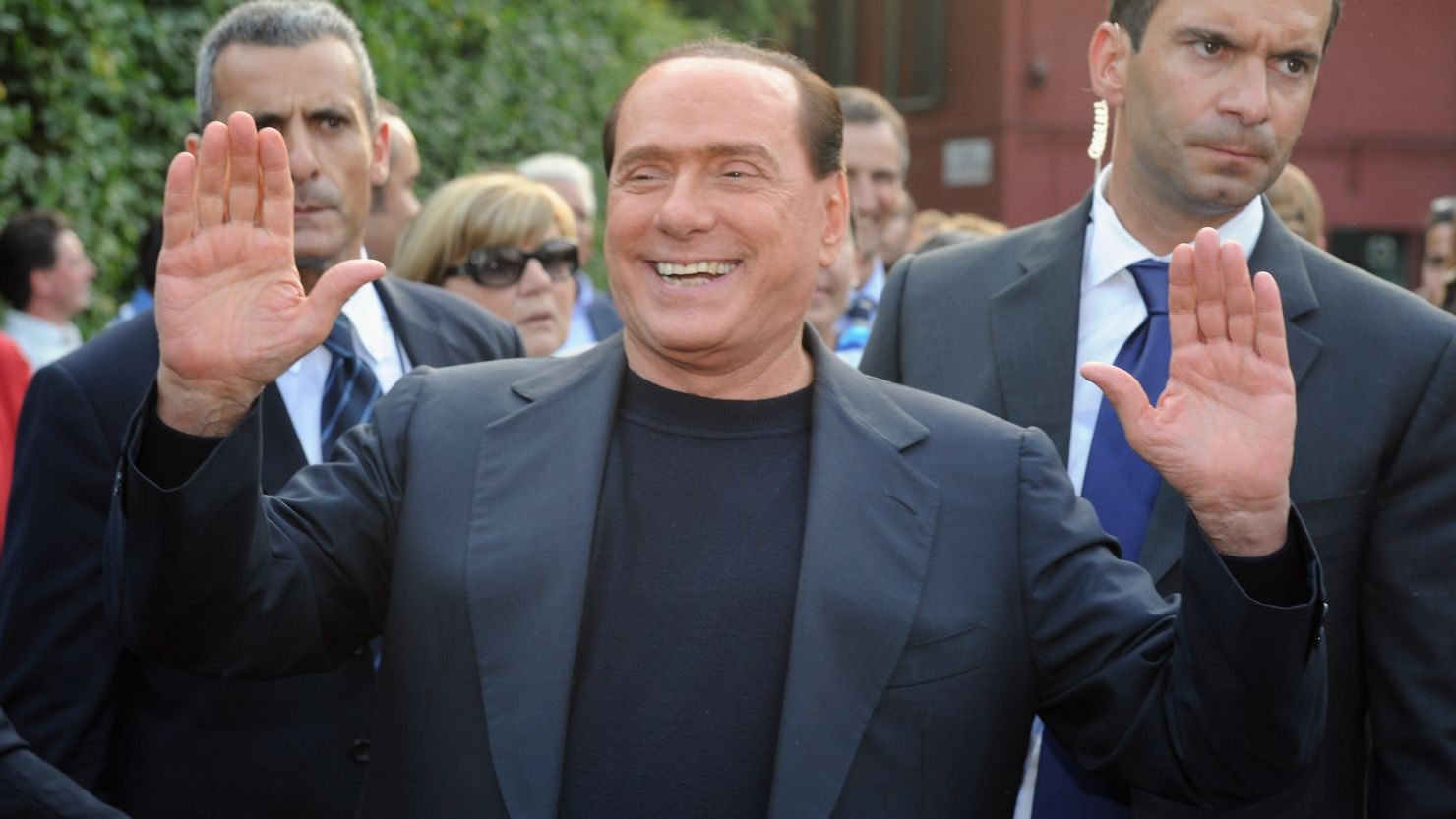 Italy's former Prime Minister Silvio Berlusconi hails supporters in front of his house in Milan in 2013.