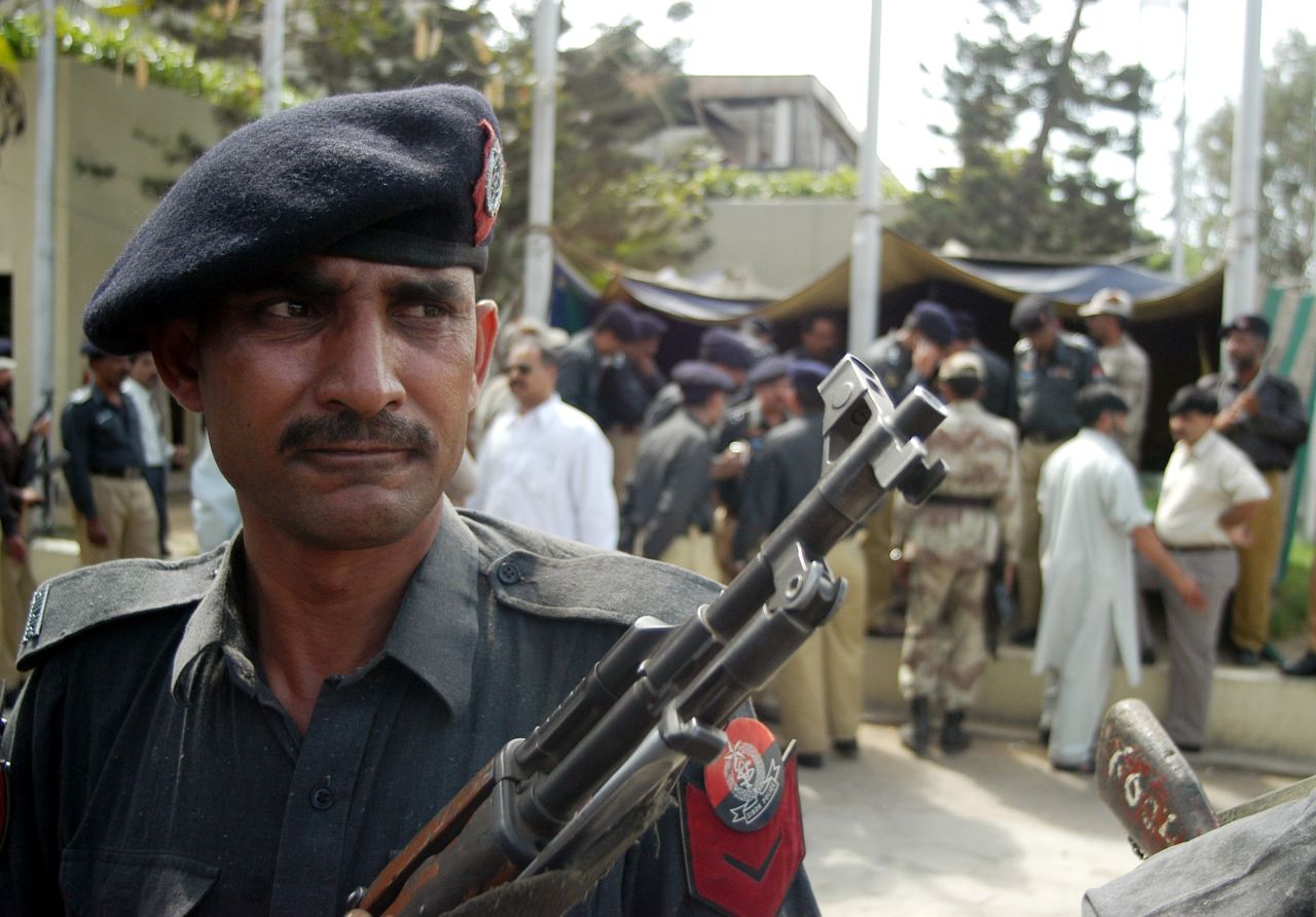 A Pakistani police officer stands guard outside the <a href="http://articles.cnn.com/2003-02-28/world/karachi.shooting_1_consulate-compound-bomb-attack-karachi">U.S. Consulate in Karachi</a> after a gunman opened fire there on February 28, 2003. Two police officers were killed, and six others, including one civilian, were injured. 