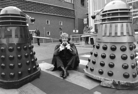 The third Doctor, played by Jon Pertwee from 1970-1974, sits in the car park of BBC Television Centre, London, guarded by two Daleks in 1972.