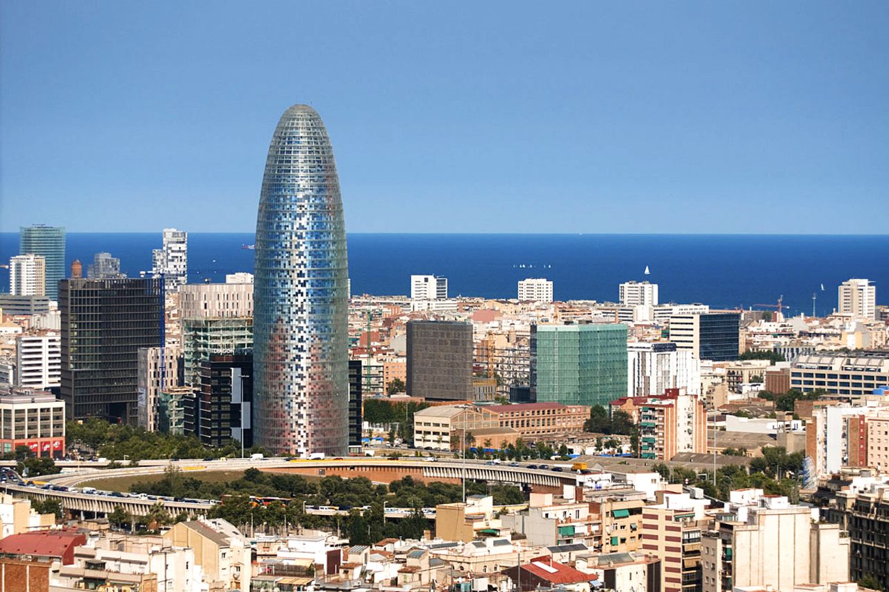 <strong>Height</strong>: 142 meters.<br /><strong>Cost to build</strong>: $130 million.<br /><strong>Completion date</strong>: 2004.<br /><strong>Fast fact</strong>: The design is inspired by a geyser, shooting up to touch the sky above Barcelona.