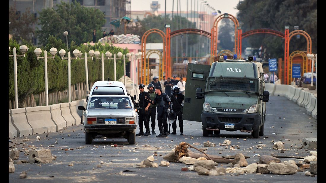 Egyptian riot police block the entrance to Sixth of October City in Giza on August 2 following clashes with Morsy supporters. 